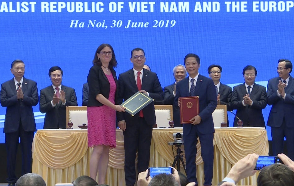 EU Commissioner for Trade Cecilia Malmstrom, front left, and Vietnamese Trade Minister Tran Tuan Anh, front right, stand together as they exchange documents aftering signing a free trade agreement in Hanoi, June 30, 2019. 