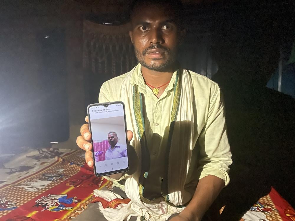 Deceased migrant phone photo held up my his son. 