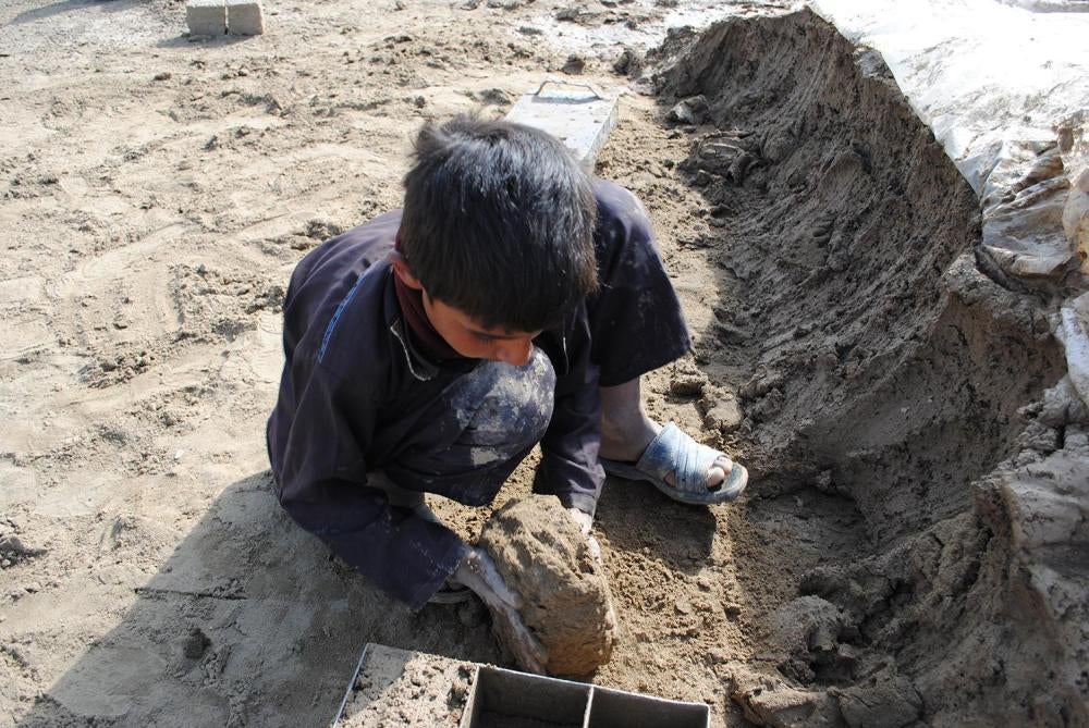 Helal, 10, works as a brick maker at a brick kiln outside Kabul. Helal doesn’t go to school because he has to work to help his family, who are bonded laborers. The family must pay off a debt for an advance they received when they accepted work as brick ma