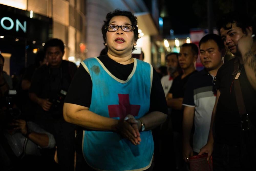 On August 30, 2017, Phayao Akhard wears the bloody nurses gown worn by her daughter, nurse Kamolkate “Kate” Akhard, when she was killed by Thai Special Forces soldiers while tending wounded persons at the front of Wat Pathum temple on May 19, 2010, to pro