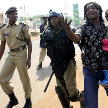 Police arrest a man with a child in a suburb of Kampala on September 11, 2009.