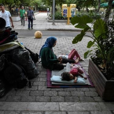 A woman sits with her children in Victoria Square in Athens, Greece, awaiting transfer after being evicted from their place of residence, July 20, 2020.