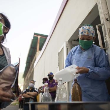 A nurse fills an empty plastic bottle with water