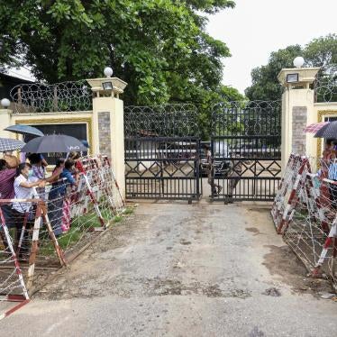 People stand outside the gates of a prison 