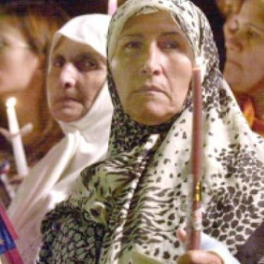 Women hold candles and American flags at a memorial in Dearborn Michigan, September 2001.