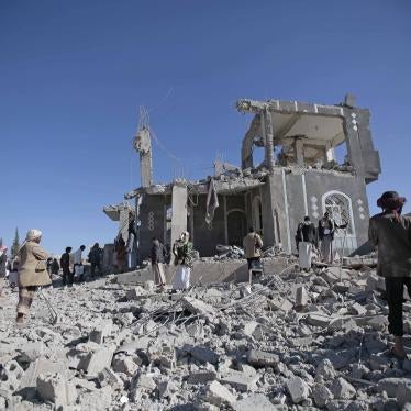 People stand in front of a damaged building