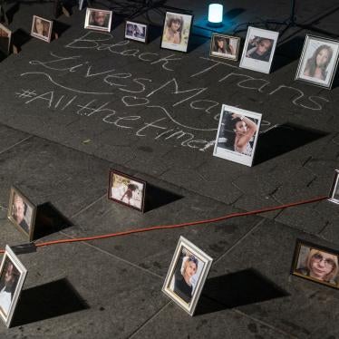 Framed photos placed on the ground around chalk writing that says "Black trans lives matter #allthetime"