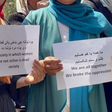 Two women hold protest signs 