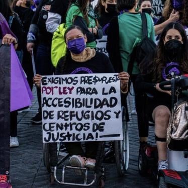 A group of women with disabilities hold a sign