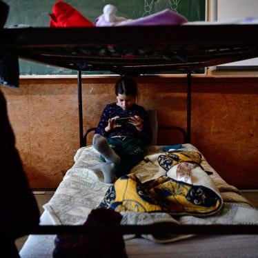 A girl looks at her phone on a bed