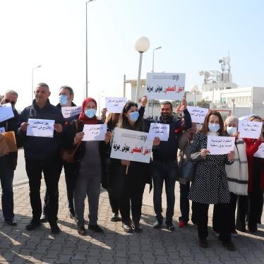A group of people holding protest signs in Arabic