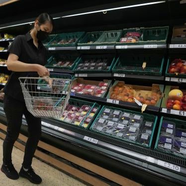 A shopper puts fruit in her basket in a supermarket in London.