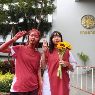 Orawan Phuphong and Tantawan Tuatulanon protest in front of the Bangkok Criminal Court by pouring red paint on themselves.