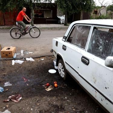 A man rides past a place where a woman was killed by a Russian cluster munition strike in Lyman, Donetsk region, Ukraine on July 8, 2023. 