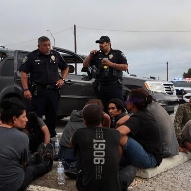 Asylum seekers from Central America sit by the road after police detained them in Hondo, Texas, about 100 miles from the US-Mexico border, June 1, 2022. 