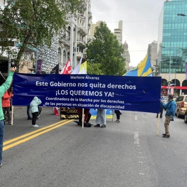 People marching with a banner down a city street