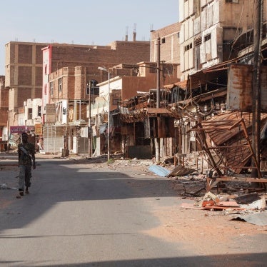 A member of the Sudanese Armed Forces (SAF) walks between damaged buildings, almost one year into the armed conflict between the Sudanese Armed Forces and the Rapid Support Forces (RSF), in Omdurman, Sudan, April 7, 2024.