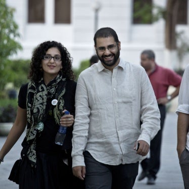 Egyptian activist Alaa Abdel-Fattah (R) walks with his sister Mona Seif prior to a conference held at the American University in Cairo, Egypt, September 22, 2014.