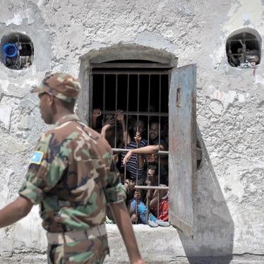 Prisoners at Mogadishu Central Prison watch as a guard walks pass their cell in December 2013. Most of the military court’s hearings in Mogadishu take place inside the prison, which limits access to hearings for relatives and independent monitors.