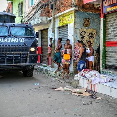 A military police armored vehicle passes by a person killed by police on April 7, 2016 in the Jacarezinho favela. Military police killed two other people during the same raid. © 2016 Carlos Cout 