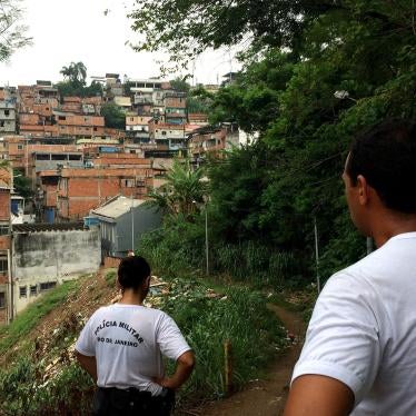 Military police officers Roberta Moreira and Wallace Justo walk through one of the trails at Mangueira favela on January 14, 2016. Members of the local Pacifying Police Unit (UPP), they carry out social projects with children to try to gain the