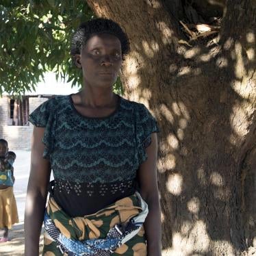Rojaina N., under the tree that served as a shelter for her family and where she and her family lived for a couple of weeks after their relocation due to coal mining operations in Mwabulambo, Karonga district. 