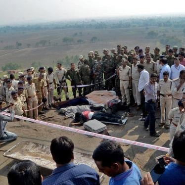 Police officers and Special Task Force soldiers stand beside dead bodies of the suspected members of the banned Students Islamic Movement of India (SIMI), who earlier today escaped the high security jail in Bhopal, and later got killed in an encounter at 