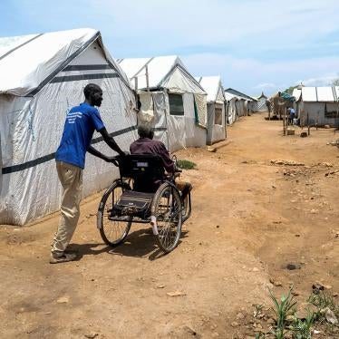 A relative pushes John Biel Dup’s wheelchair through the dirt paths of Protection of Civilians Camp 3 in Juba,. The uneven paths make it difficult for people with physical disabilities to move around the camps..