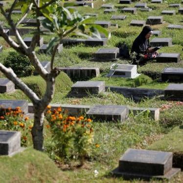 201711Asia_Indonesia_1965 Two people pray at the grave of a loved one in Jakarta, Indonesia, June 26, 2017.
