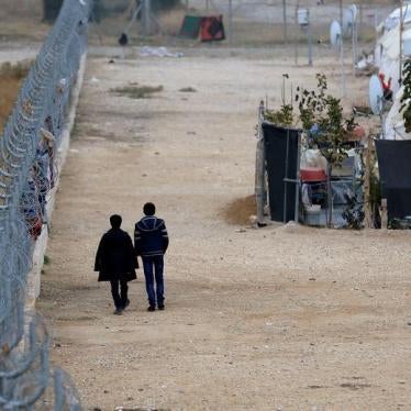 Two Syrians walk along a fence near the Turkish-Syrian border in Gaziantep province, Turkey on November 30, 2016. 