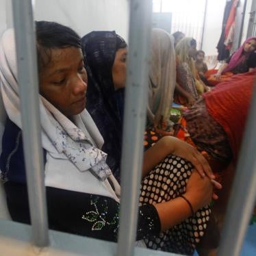 Rohingya refugees sit behind bars at a police station in Satun province, Thailand, June 12, 2019.