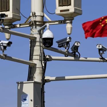 A Chinese national flag flutters near surveillance cameras mounted on a lamp post in Beijing, March 15, 2019. 