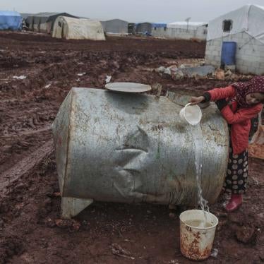 A displaced Syrian girl fills water from a cistern at a camp for Syrian displaced people near the Syrian-Turkish border in the Northern countryside of Idlib. 